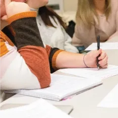 A group of students writing at a table.